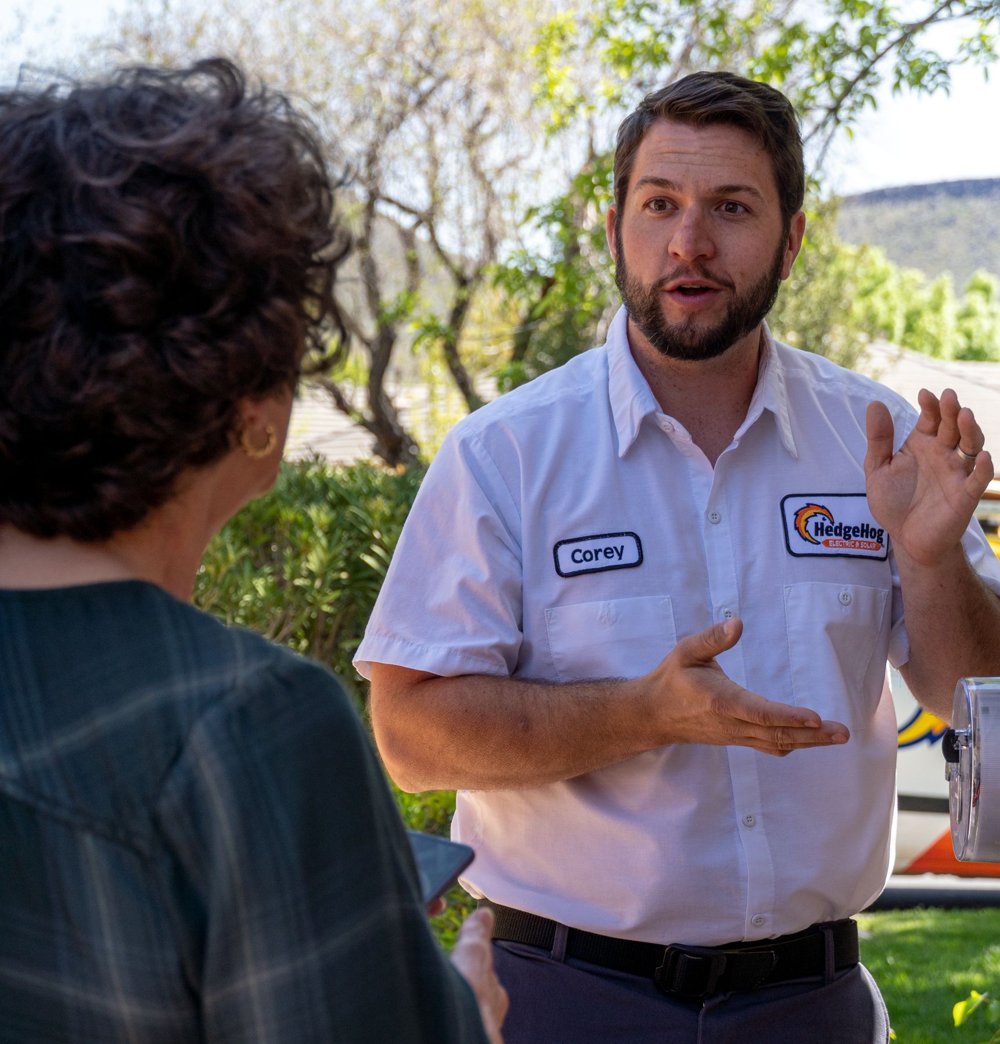 A service technician talking with a homeowner outside her home